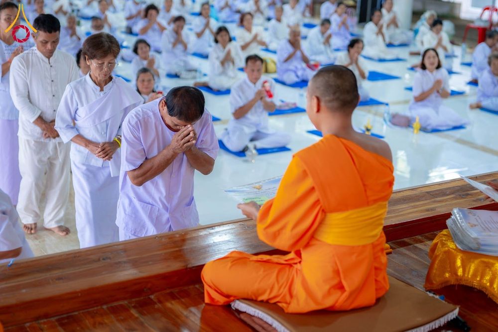 ผู้เข้าร่วมโครงการอบรมชุดขาวก้มกราบรับประกาศนียบัตรจากพระภิกษุสงฆ์