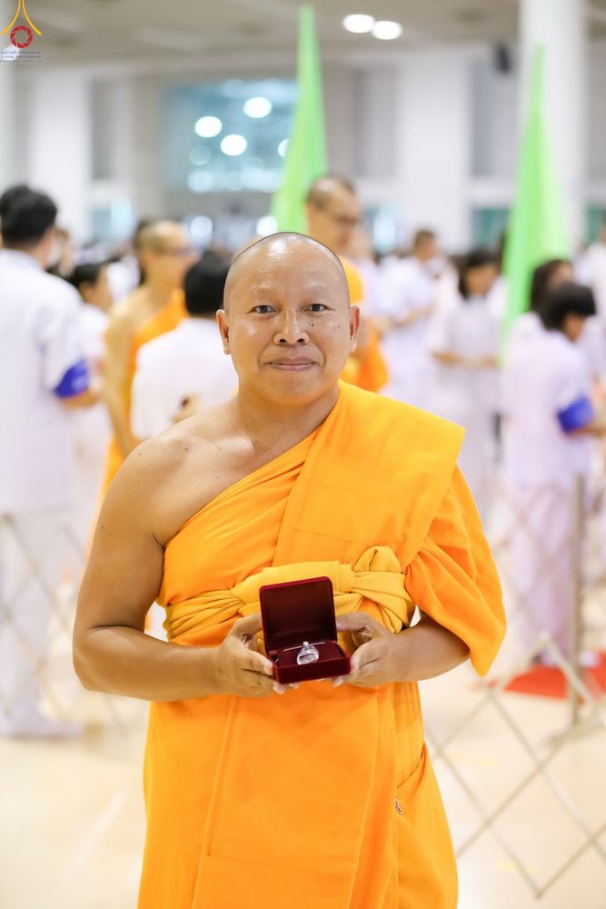 พระภิกษุสงฆ์ถือกล่องพระของขวัญสีแดงในมือ