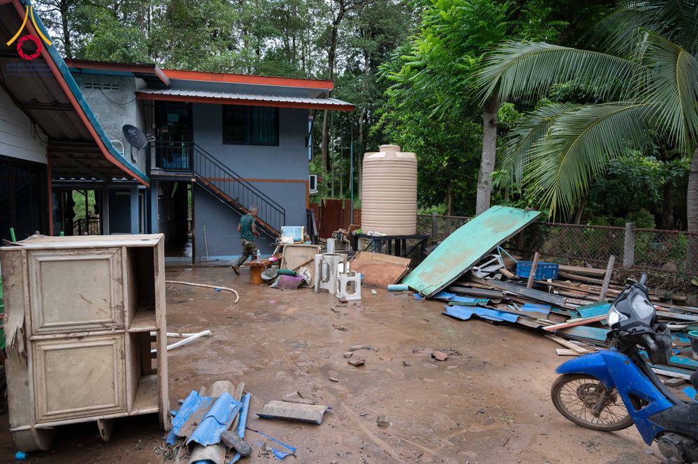พื้นที่บ้านที่มีคราบโคลนและเศษวัสดุจากการถูกน้ำท่วมขัง