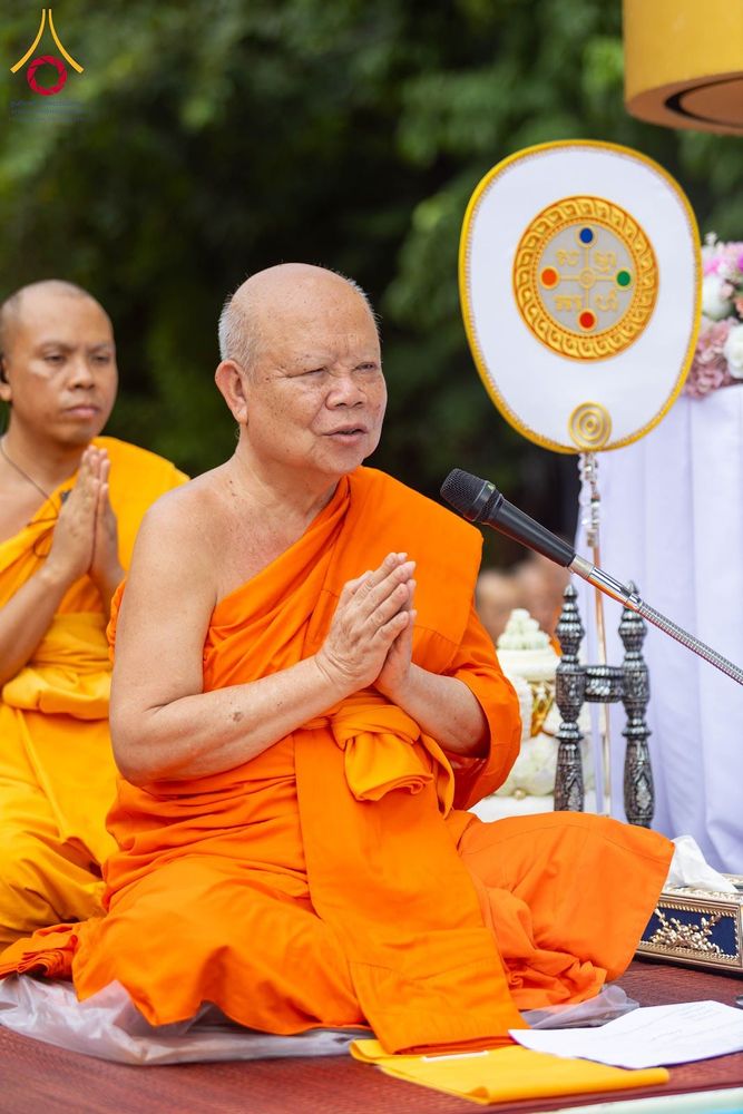 พระสงฆ์กำลังประนมมือและกล่าวผ่านไมโครโฟนในพิธีกรรมทางศาสนา