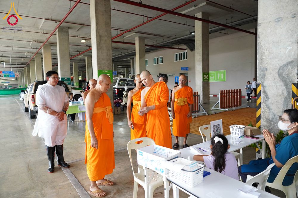 พระภิกษุสงฆ์เดินตรวจเยี่ยมพื้นที่อาคารจอดรถโดยมีเจ้าหน้าที่คอยต้อนรับ