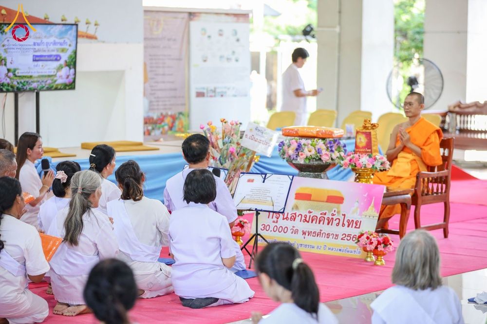 กลุ่มผู้เข้าร่วมโครงการสวมชุดขาวนั่งฟังธรรมจากพระภิกษุสงฆ์ในงานทอดกฐินสามัคคี