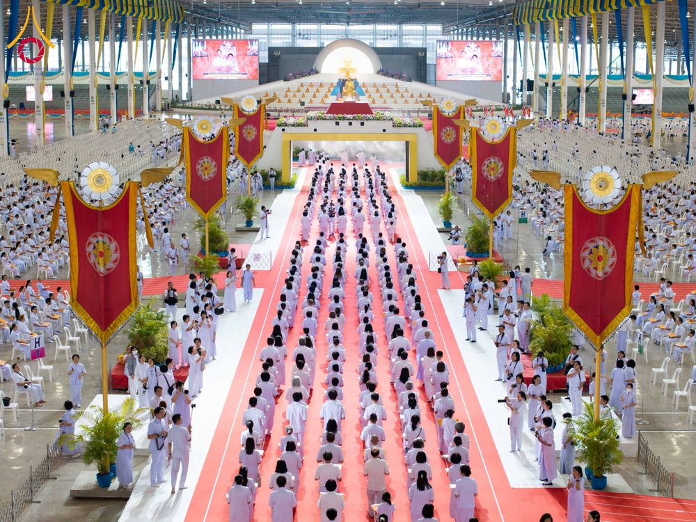 พุทธศาสนิกชนสวมชุดขาวจำนวนมากร่วมพิธีทอดผ้าป่าสมทบกฐินภายในอาคารสภาธรรมกายสากล