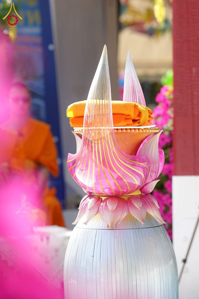 พานพุ่มสีชมพูวางผ้าไตรจีวรสีเหลืองทองในพิธีทางศาสนา
