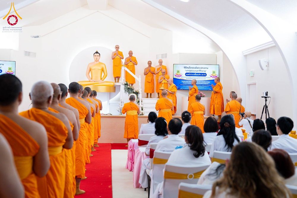 พระภิกษุสงฆ์และสาธุชนกำลังประกอบพิธีทางศาสนาหน้าพระประธานภายในอาคารวัด