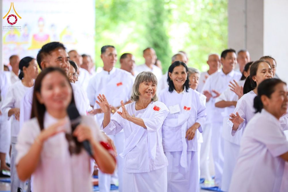 กลุ่มผู้เข้าร่วมโครงการอบรมในชุดสีขาวกำลังทำกิจกรรมร่วมกันด้วยความเบิกบานใจ