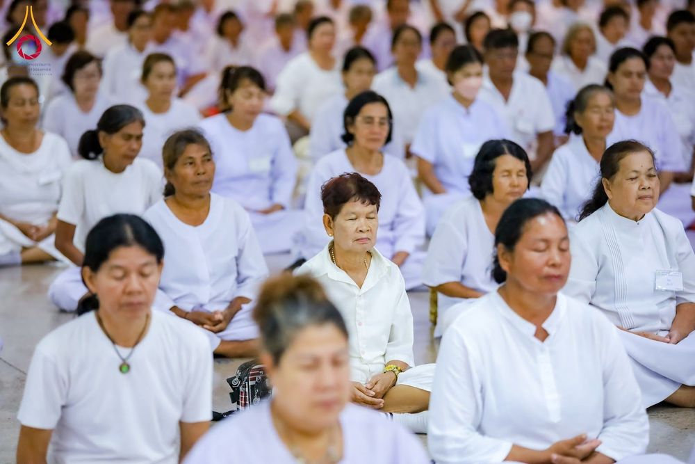 กลุ่มอุบาสิกาหลายท่านสวมชุดสีขาวนั่งหลับตาทำสมาธิในพื้นที่ปฏิบัติธรรม