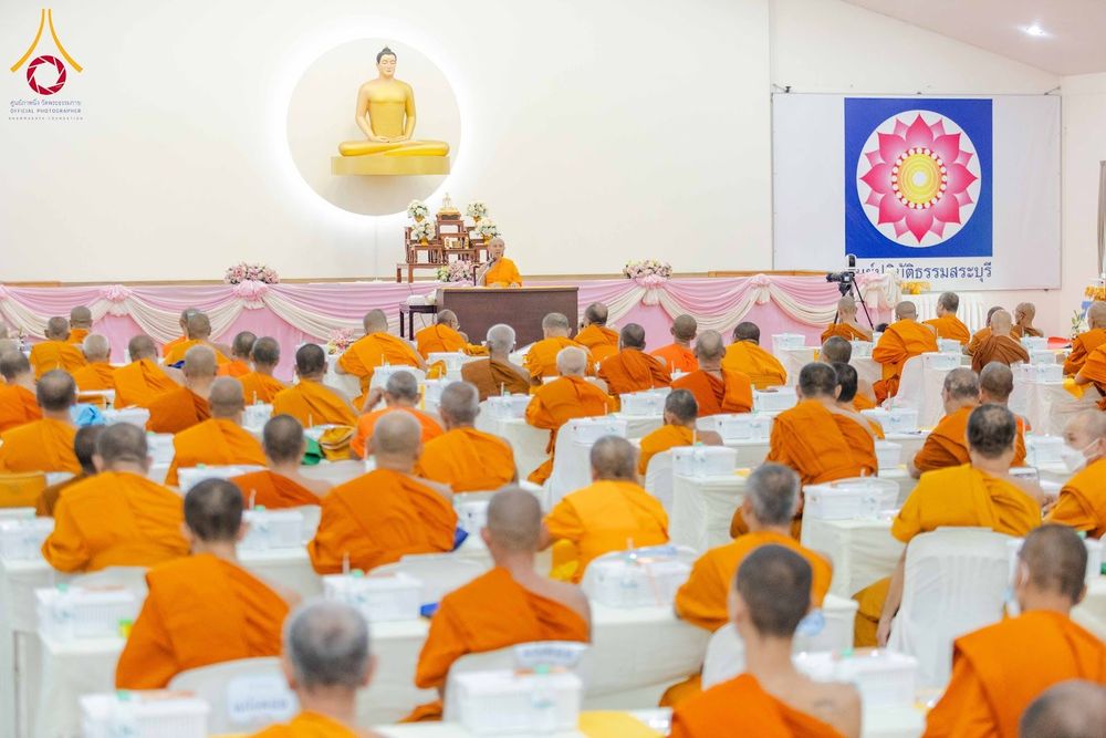 พระภิกษุสงฆ์จำนวนมากนั่งฟังการบรรยายภายในห้องประชุมที่มีพระอาจารย์เป็นผู้บรรยายบนเวที