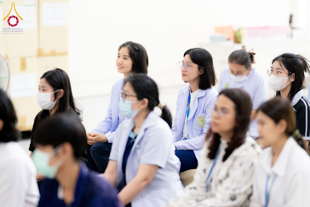 กลุ่มบุคลากรทางการแพทย์สวมหน้ากากอนามัยนั่งฟังการบรรยายภายในอาคาร