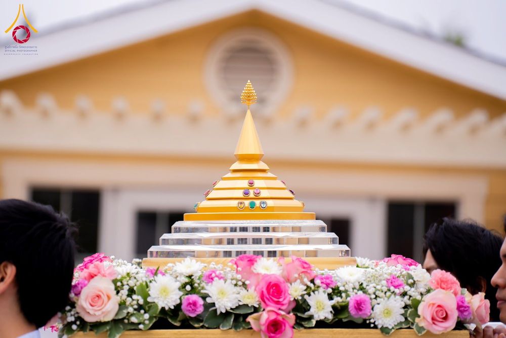 ผอบสีทองประดับอัญมณีวางบนพานดอกไม้ในพิธีทางศาสนา