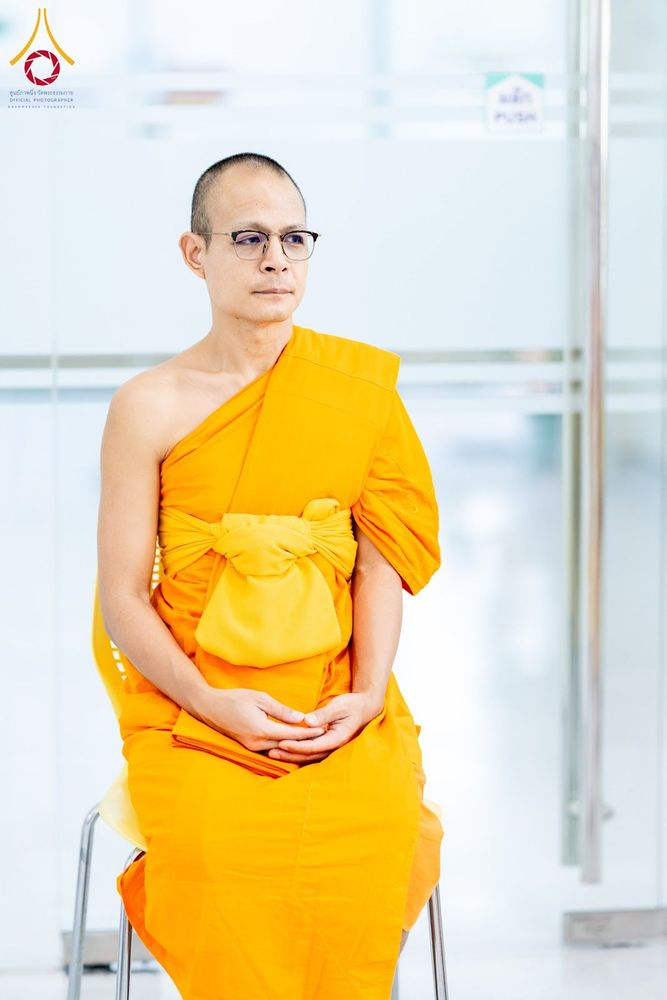 พระภิกษุสงฆ์สวมแว่นตานั่งสำรวมบนเก้าอี้