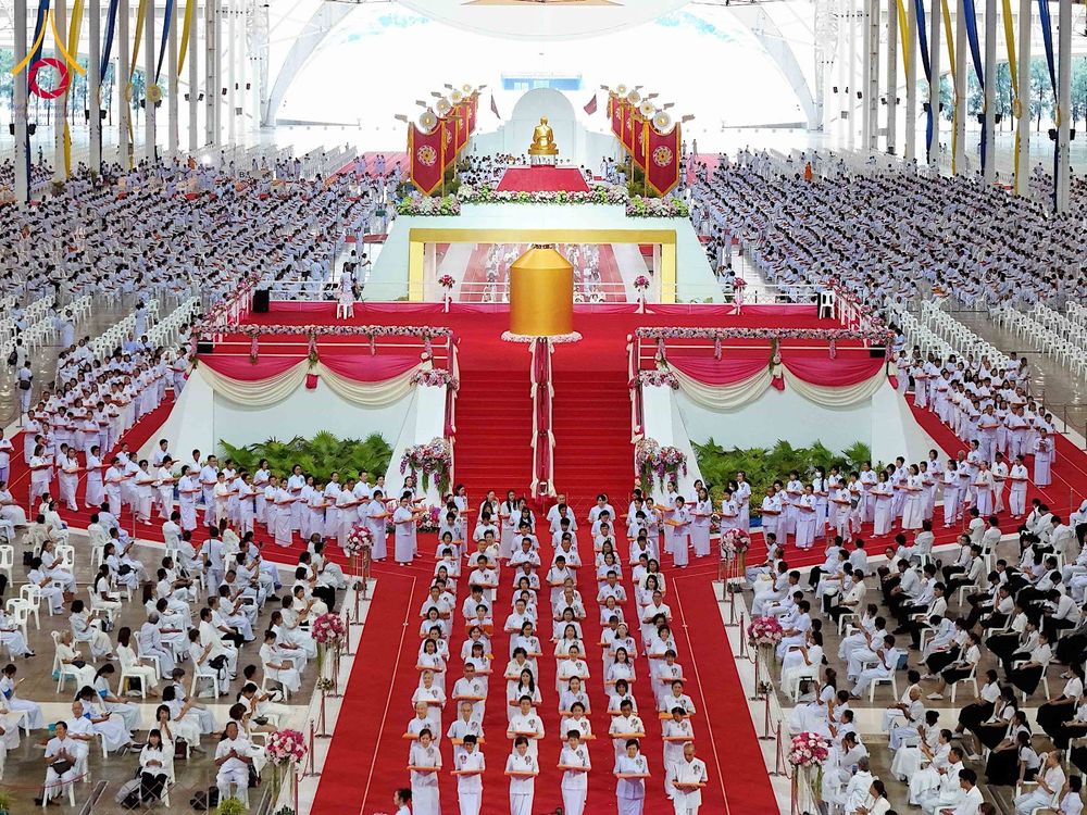 พุทธศาสนิกชนสวมชุดขาวจำนวนมากร่วมพิธีทอดผ้าป่าภายในอาคารสภาธรรมกายสากล