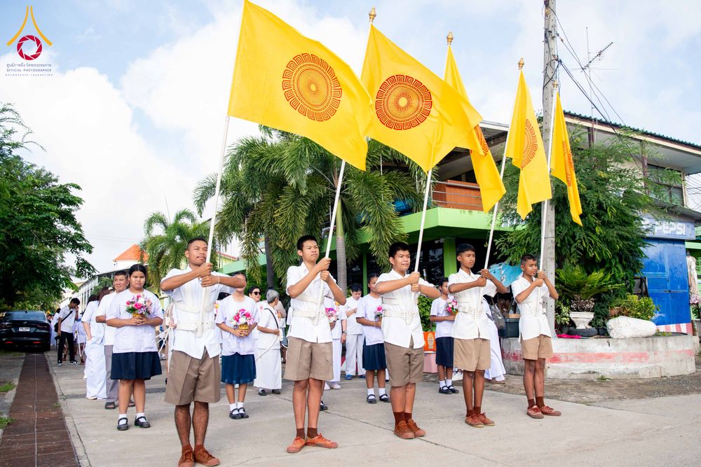 กลุ่มเยาวชนชายถือธงสีเหลืองสัญลักษณ์ธรรมจักรในขบวนพิธีทางศาสนา