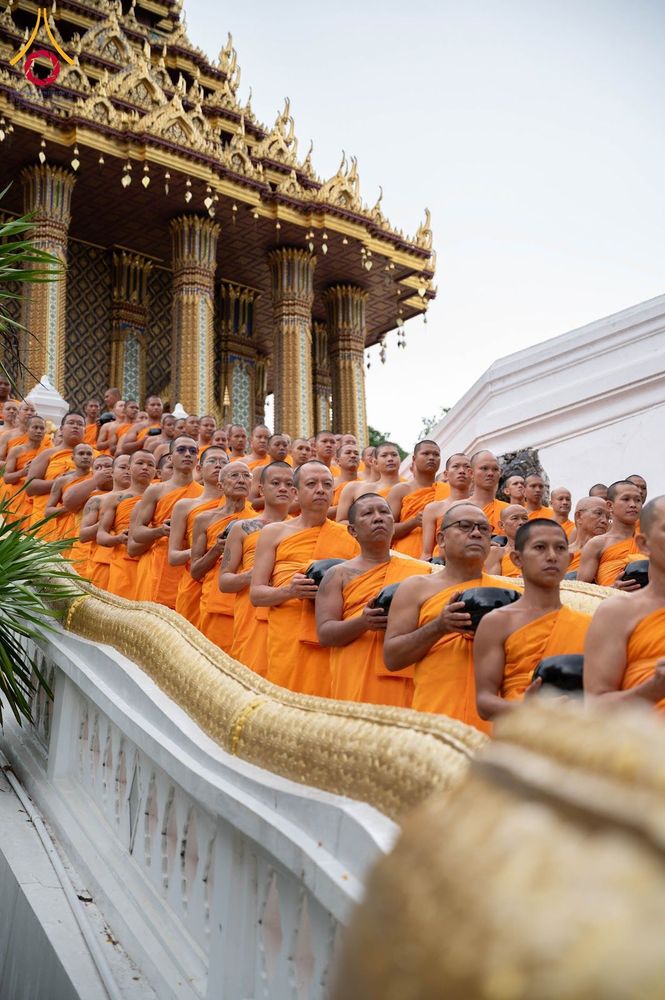 กลุ่มสามเณรเดินเรียงแถวถือบาตรรับบิณฑบาตหน้าพระอุโบสถ