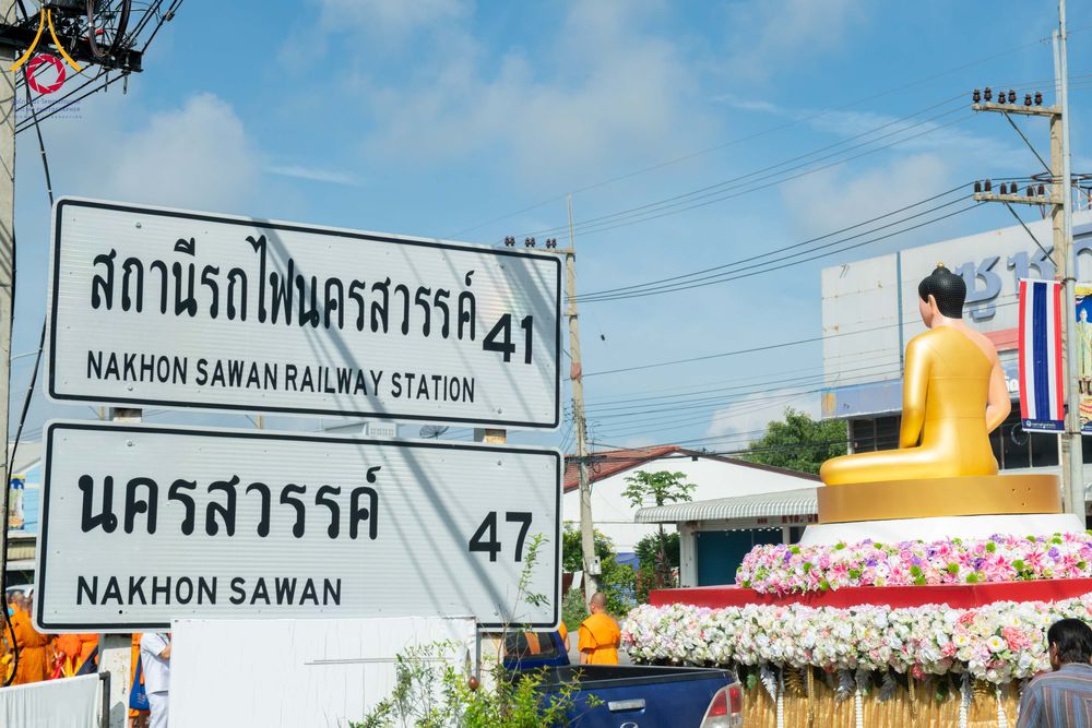 ป้ายสถานีรถไฟนครสวรรค์และพระพุทธรูปสีทองบนรถประดับดอกไม้