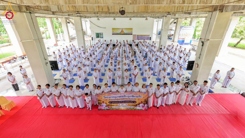 กลุ่มผู้เข้าร่วมโครงการอบรมในชุดขาวจำนวนมากยืนเรียงแถวภายในอาคารเพื่อถ่ายภาพร่วมกัน