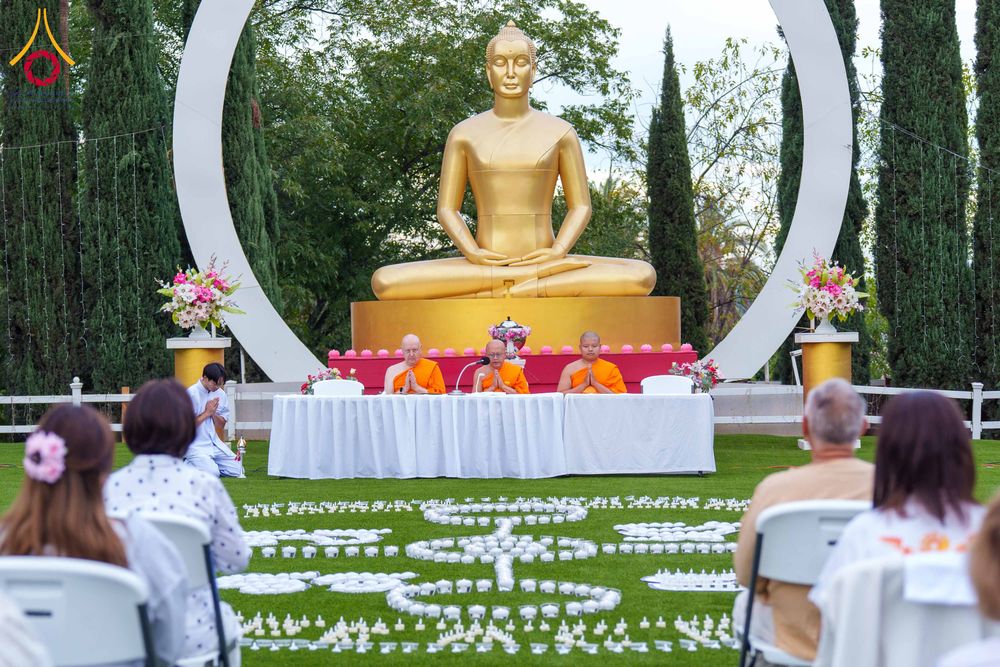 พระภิกษุสงฆ์และสาธุชนร่วมกิจกรรมนั่งสมาธิและจุดประทีปกลางแจ้งหน้าพระพุทธรูปสีทอง