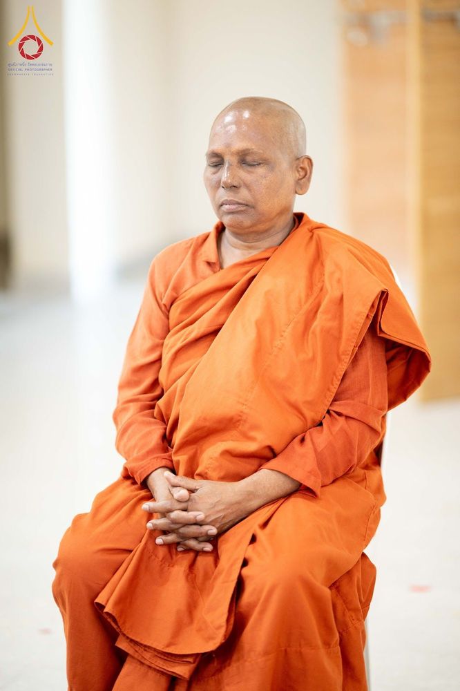พระภิกษุสงฆ์ครองจีวรสีส้มกำลังนั่งหลับตาทำสมาธิอย่างสงบ
