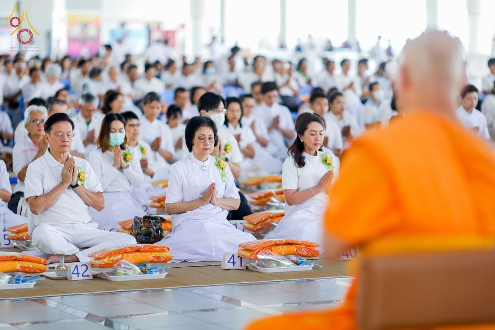 พุทธศาสนิกชนแต่งกายชุดขาวนั่งพนมมือประกอบพิธีบุพเปตพลีภายในหอฉันคุณยายอาจารย์มหารัตนอุบาสิกาจันทร์ ขนนกยูง