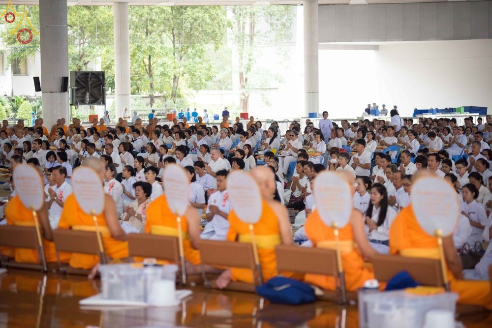 พุทธศาสนิกชนสวมชุดขาวนั่งพนมมือร่วมพิธีปุพพเปตพลีโดยมีพระภิกษุสงฆ์นำประกอบพิธีกรรม ณ หอฉันคุณยายอาจารย์ฯ วัดพระธรรมกาย
