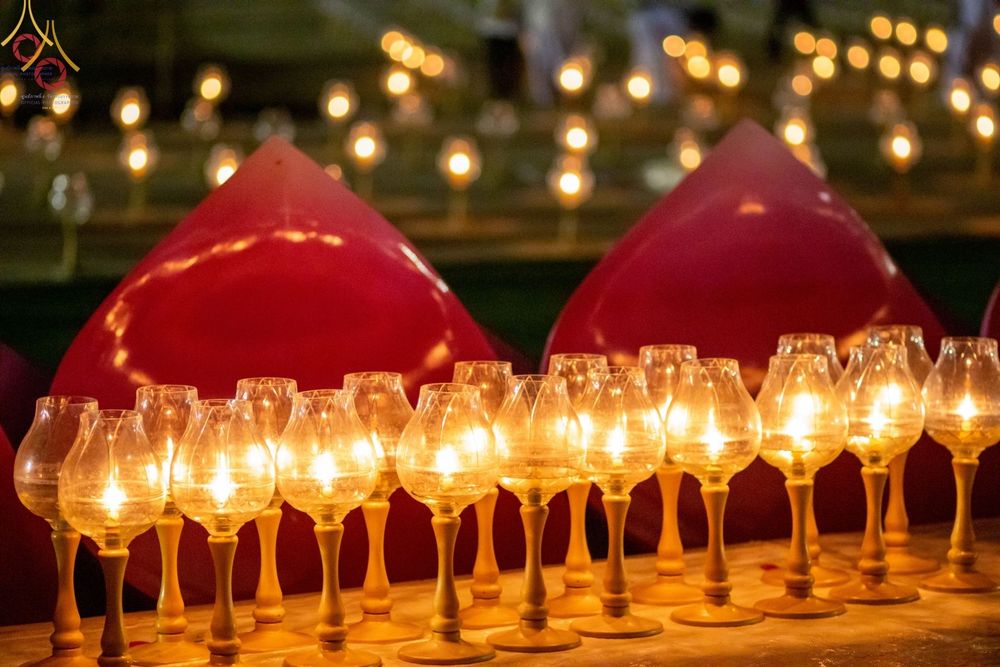 แถวของประทีปในแก้วใสที่จุดไฟสว่างไสววางเรียงรายในพิธีจุดประทีปถวายเป็นพุทธบูชา ณ อนุสรณ์สถานบางปลา