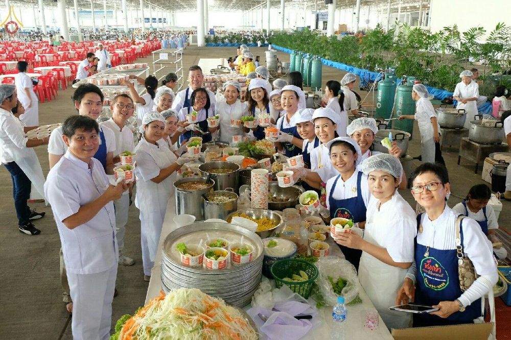 กลุ่มอาสาสมัครชายหญิงกำลังช่วยกันจัดเตรียมอาหารใส่ถ้วยเพื่อแจกจ่ายในงานวันสมาธิโลก