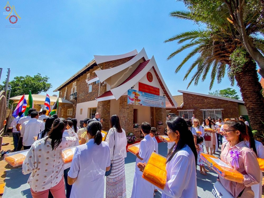 กลุ่มพุทธศาสนิกชนถือผ้าไตรจีวรเตรียมประกอบพิธีทอดกฐินสามัคคีหน้าอุโบสถวัดพระธรรมกายโจฮันเนสเบิร์ก