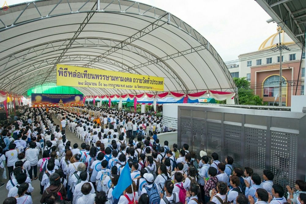 พุทธศาสนิกชนจำนวนมากสวมชุดขาวเข้าร่วมพิธีหล่อเทียนพรรษามหามงคล เพื่อถวายวัดทั่วประเทศ ภายใต้เต็นท์ขนาดใหญ่ ณ วัดพระธรรมกาย