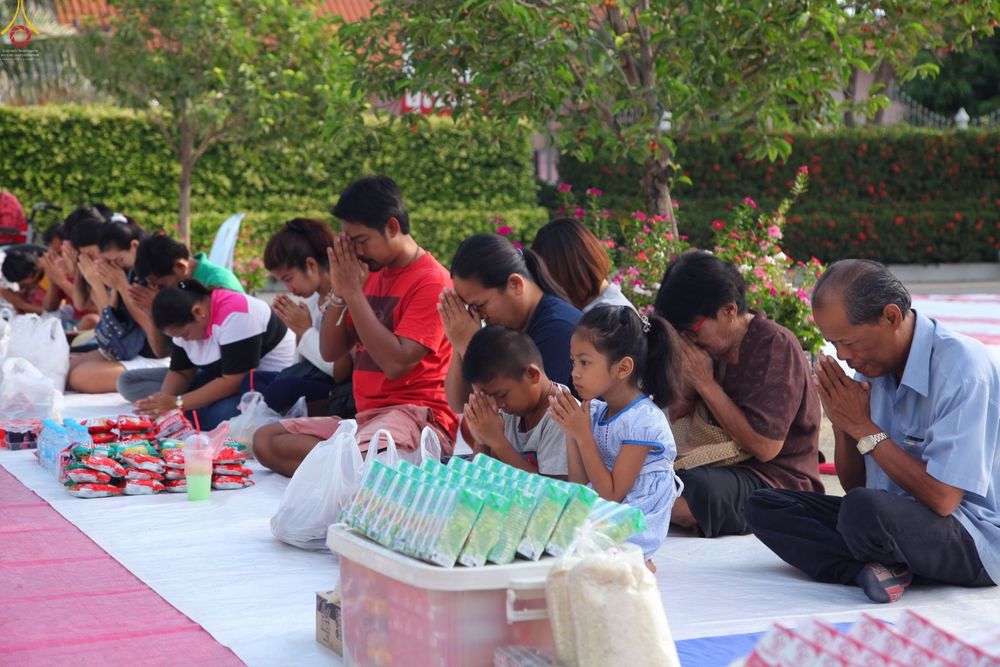 กลุ่มพุทธศาสนิกชนนั่งพนมมือเตรียมตักบาตรพระภิกษุสามเณรภายในวัดดอนใหญ่