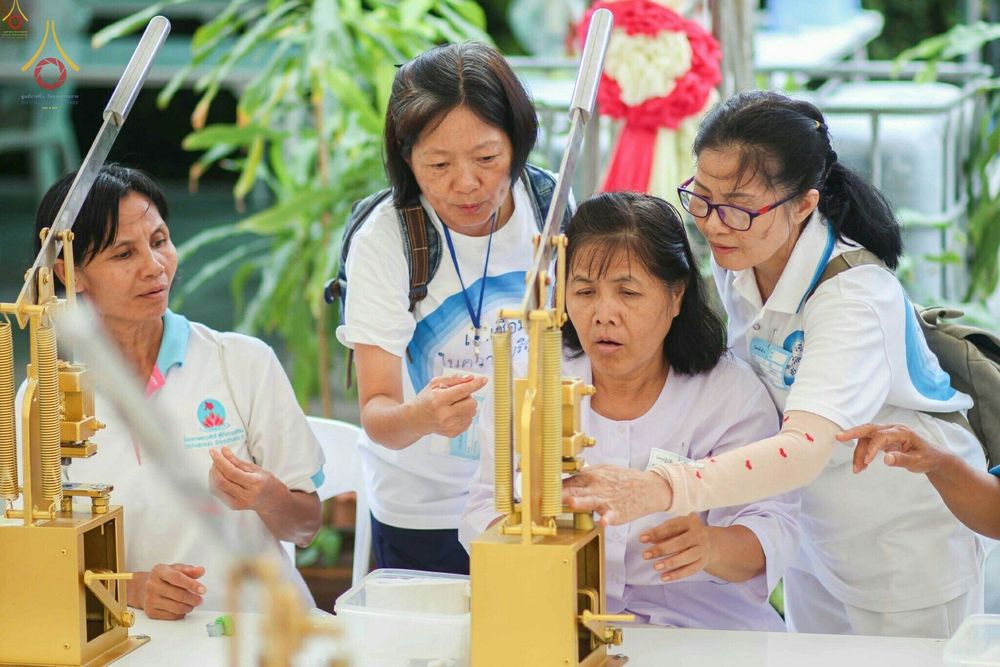 กลุ่มพุทธศาสนิกชนกำลังช่วยกันใช้เครื่องมือพิมพ์พระของขวัญรุ่นบรรลุธรรมอย่างตั้งใจ