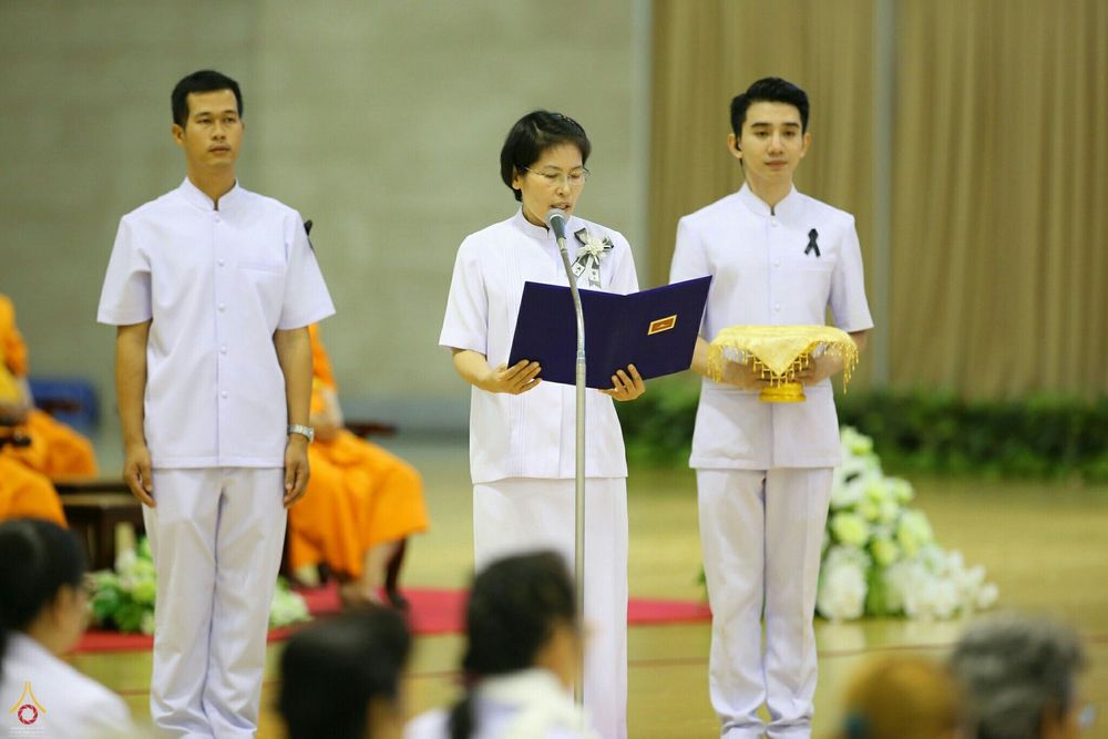เจ้าหน้าที่ในชุดสีขาวกำลังประกอบพิธีบำเพ็ญกุศลสตมวาร 100 วัน
