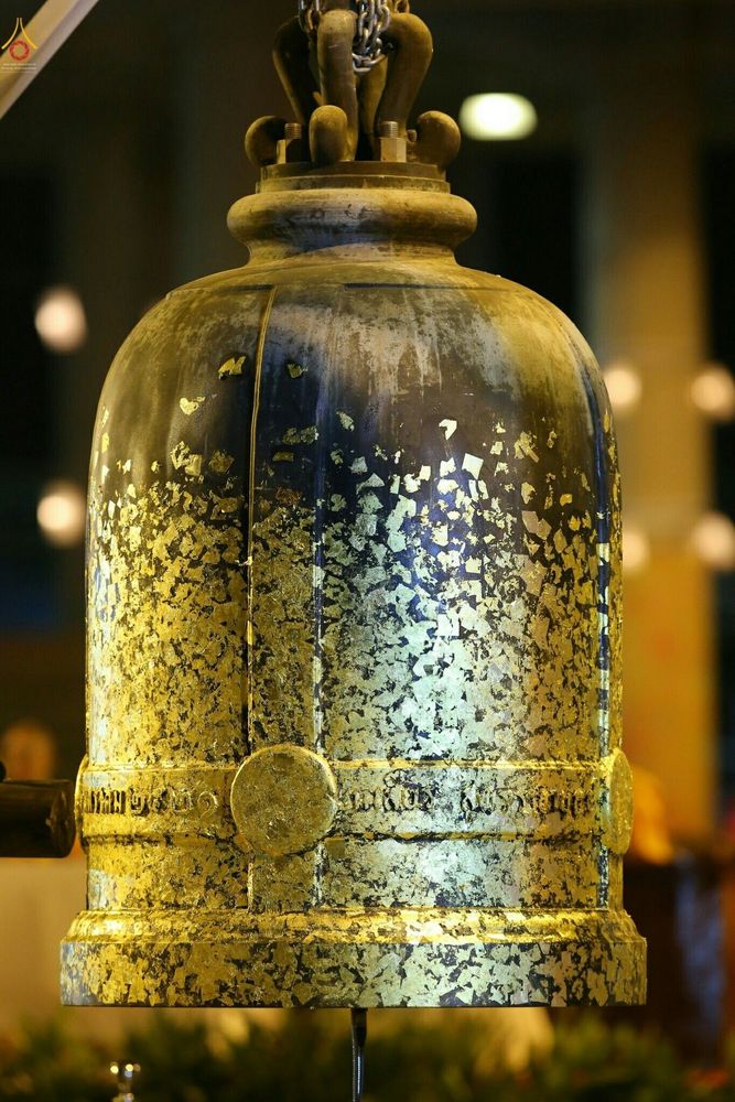 ระฆังโลหะสีเข้มที่ได้รับการปิดทองคำเปลวทั่วทั้งองค์อย่างประณีตในพิธีทางศาสนา
