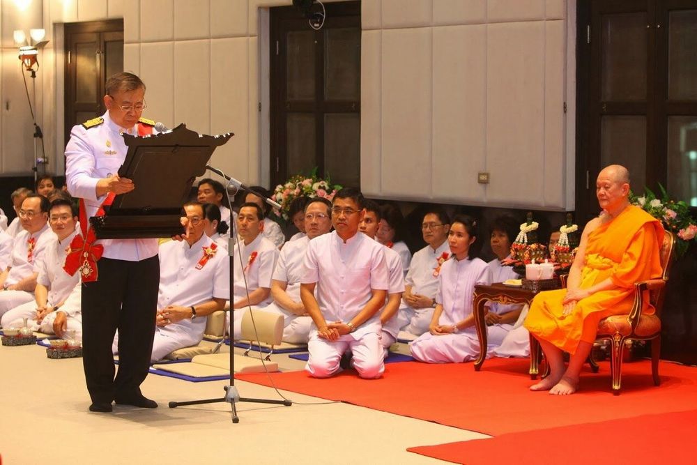 เจ้าหน้าที่อ่านประกาศเกียรติคุณในพิธีมุทิตาสักการะพระราชภาวนาจารย์ โดยมีพระสงฆ์นั่งบนอาสนะและพุทธศาสนิกชนนั่งพับเพียบร่วมพิธี