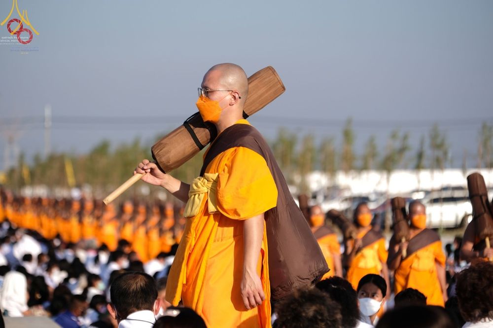 พระสงฆ์ในโครงการธรรมยาตรากตัญญูบูชาสะพายกลดเดินแถวท่ามกลางพุทธศาสนิกชนที่มาร่วมต้อนรับ ณ อนุสรณ์สถานบางปลา