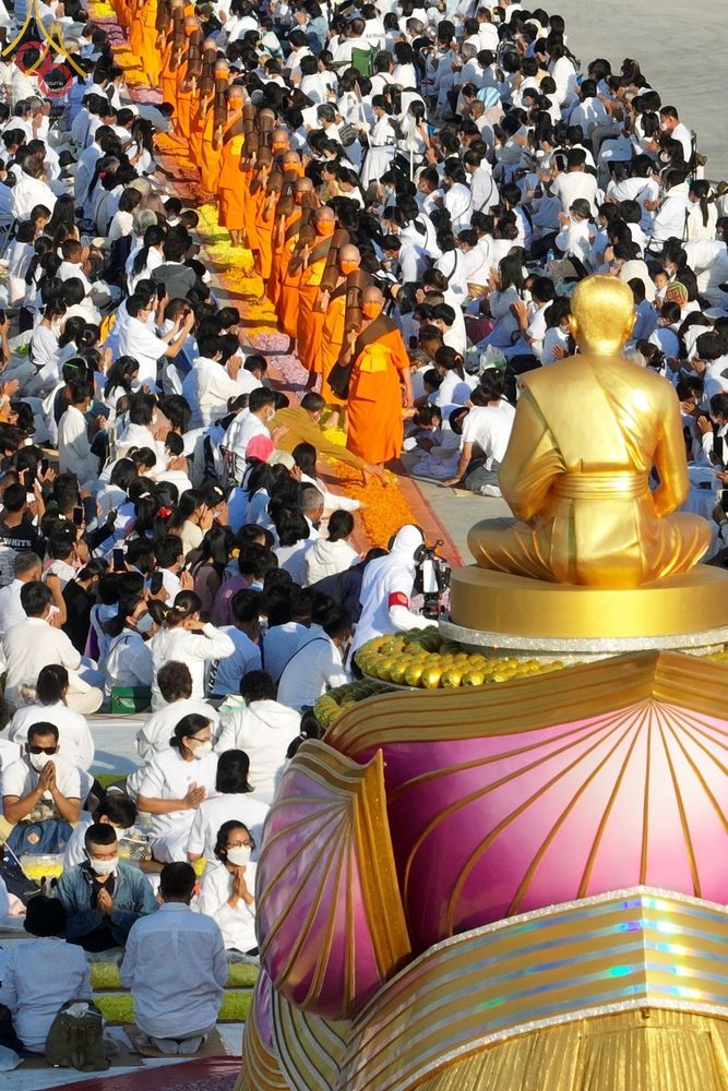 คณะพระธรรมยาตราเดินธุดงค์ท่ามกลางสาธุชนที่สวมชุดขาวมารอรับในพิธี ณ อนุสรณ์สถานบางปลา