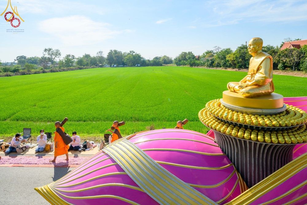 คณะพระธรรมยาตราเดินธุดงค์ผ่านรูปหล่อทองคำพระมงคลเทพมุนีบนฐานดอกบัวสีชมพู ณ อนุสรณ์สถานบางปลา