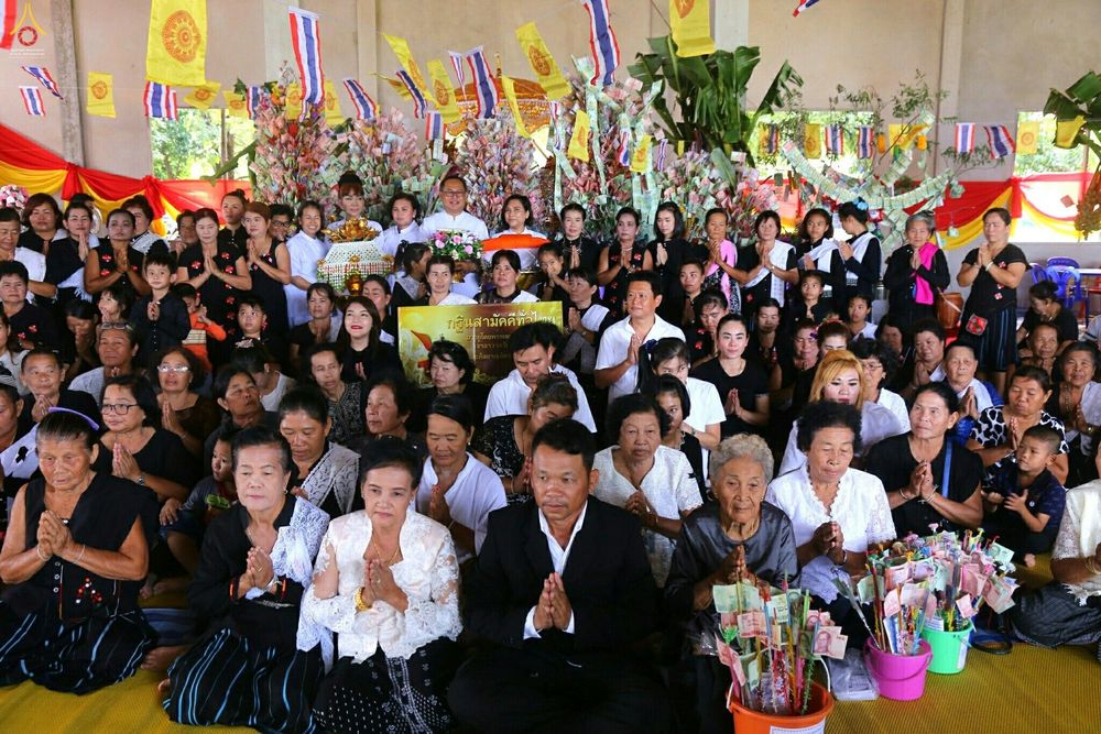 กลุ่มพุทธศาสนิกชนชายหญิงนั่งพนมมือร่วมพิธีทอดกฐินสามัคคีภายในศาลาวัดดอนมะกอก จังหวัดนครปฐม