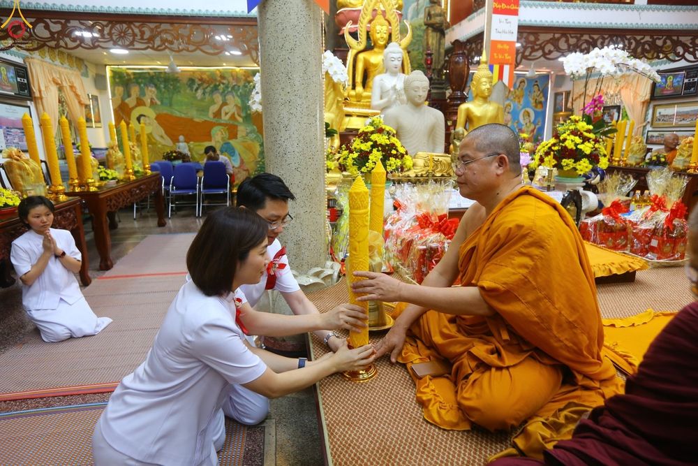 พุทธศาสนิกชนกำลังถวายเทียนพรรษาแด่พระภิกษุสงฆ์ในพิธีทางศาสนา