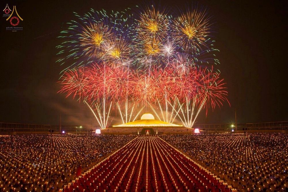 พุทธศาสนิกชนจำนวนมากถือประทีปในพิธีจุดประทีปบูชาพระมหาธรรมกายเจดีย์ท่ามกลางการแสดงพลุบนท้องฟ้า
