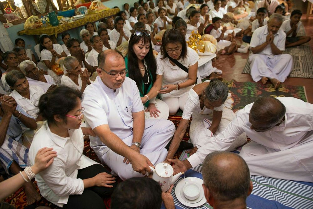 กลุ่มพุทธศาสนิกชนกำลังร่วมพิธีรินน้ำกรวดในงานทอดกฐินสามัคคีที่วัดหลวงวาตาโกด้า ประเทศศรีลังกา
