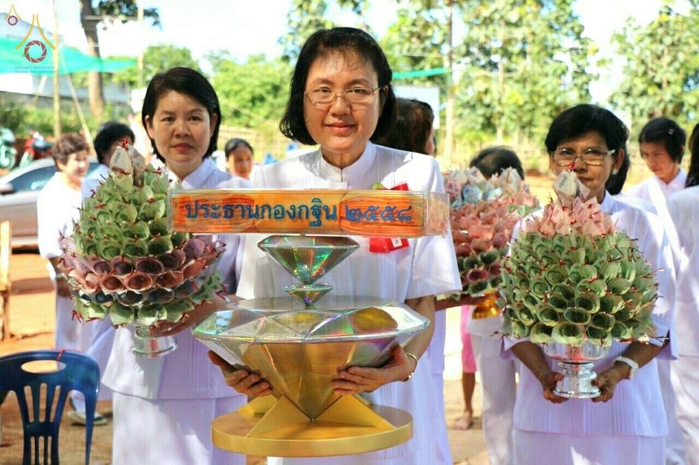 กลุ่มพุทธศาสนิกชนสวมชุดขาวถือพานพุ่มเงินและพานประธานกองกฐินในงานบุญปฐมกฐิน