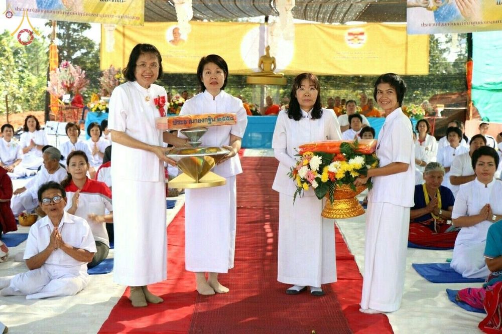 กลุ่มพุทธศาสนิกชนหญิงในชุดขาวถือพานพุ่มและผ้าไตรกฐินในพิธีทอดกฐิน ณ ศูนย์ปฏิบัติธรรมขุนยวม