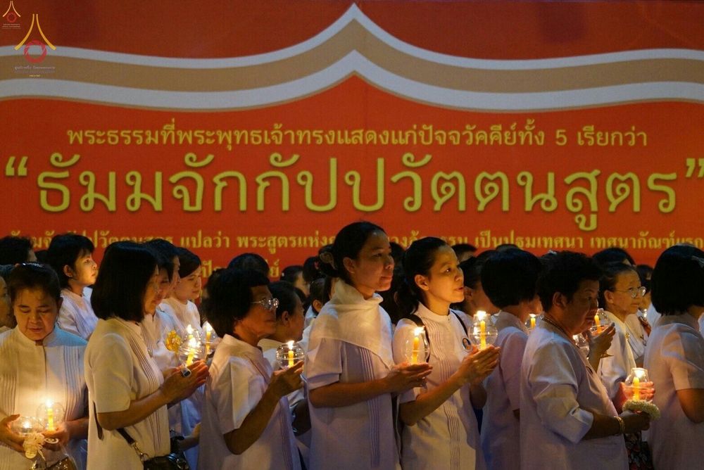 กลุ่มพุทธศาสนิกชนชุดขาวถือเทียนร่วมพิธีในวันครูผู้ค้นพบวิชชาธรรมกาย