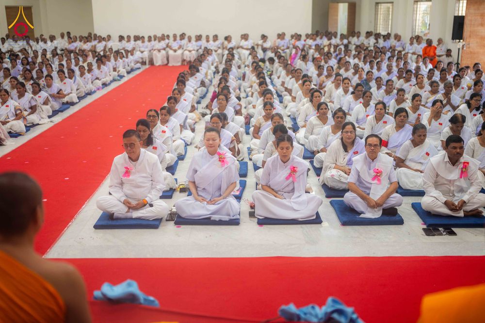กลุ่มอุบาสกและอุบาสิกาชุดขาวนั่งสมาธิในพิธีปิดโครงการอบรมภายในอาคาร