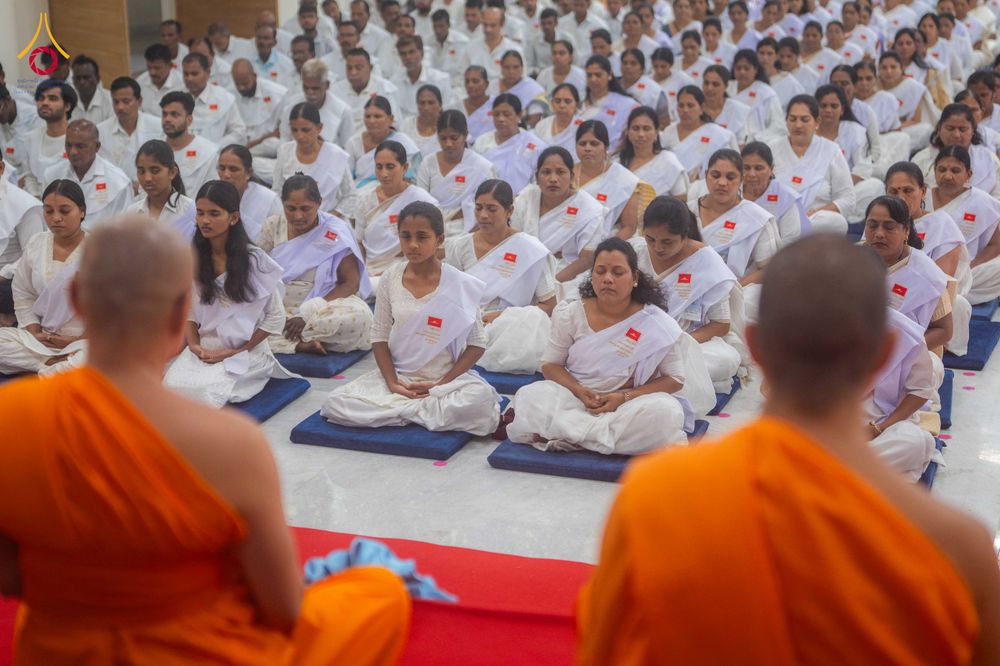กลุ่มอุบาสกและอุบาสิกาชุดขาวนั่งสมาธิร่วมกับพระภิกษุในพิธีปิดโครงการอบรม