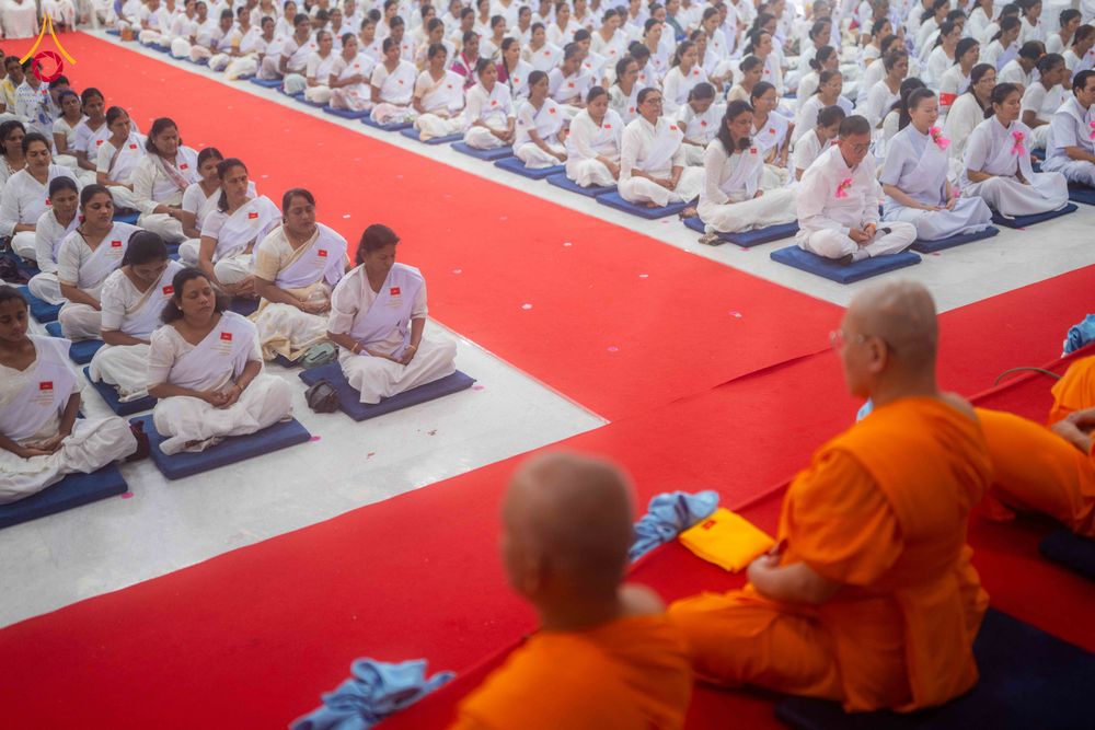 กลุ่มอุบาสกและอุบาสิกาชุดขาวนั่งสมาธิร่วมกับพระภิกษุในพิธีปิดโครงการอบรม