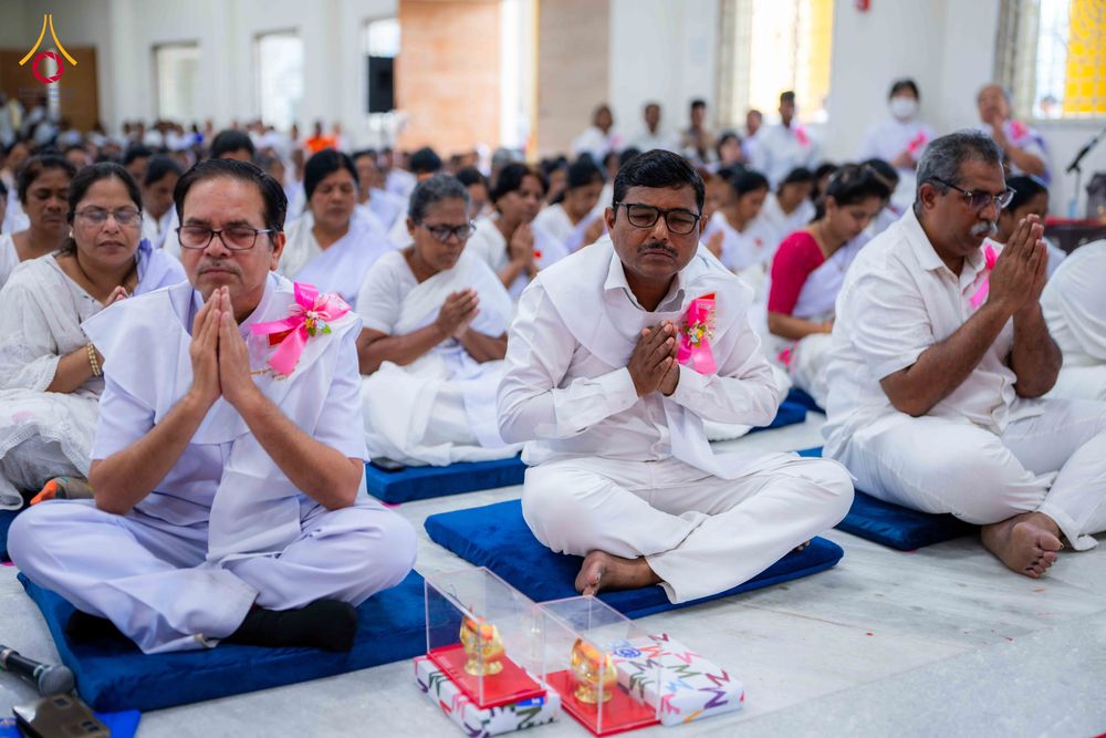 กลุ่มอุบาสกและอุบาสิกาสวมชุดขาวนั่งพนมมือปฏิบัติธรรมในพิธีปิดโครงการอบรม