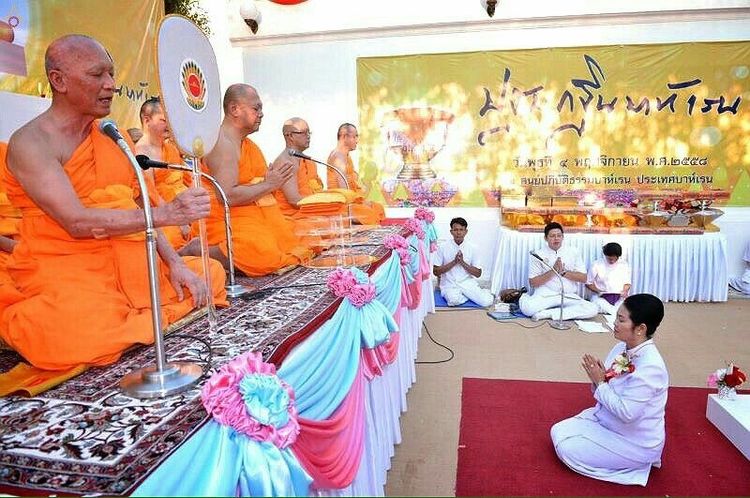 พระภิกษุสงฆ์กำลังประกอบพิธีทางศาสนาในงานทอดกฐินโดยมีพุทธศาสนิกชนนั่งพนมมือรับฟังธรรม