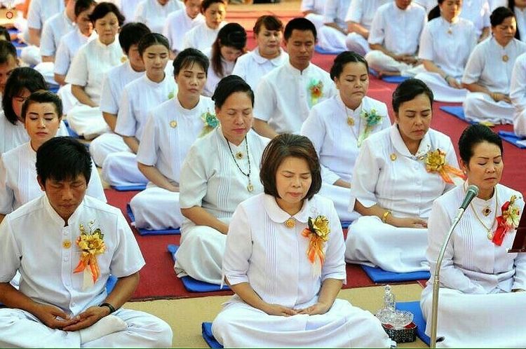กลุ่มพุทธศาสนิกชนสวมชุดขาวนั่งสมาธิในพิธีทอดกฐิน