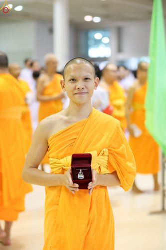 พระภิกษุสงฆ์ถือกล่องพระของขวัญสีแดงในมือ